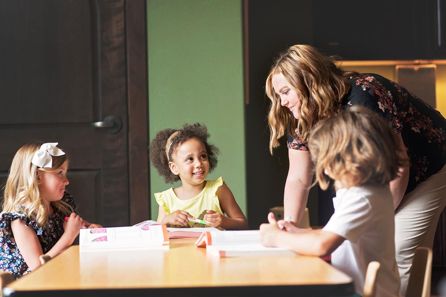 Teacher in discussion with children A teacher talking through a classroom activity with students